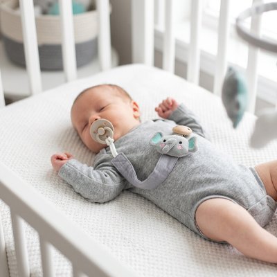 Attache tetine bébé est reconforté avec sa suçe qui est retenu par son attache suce