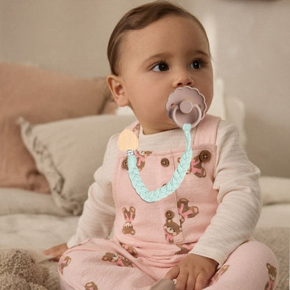 bebe attend maman pattiement avec son attache tetine