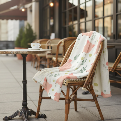 couverture bebe cochon déposé négligemment sur une chaise de bistro extérieur

