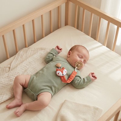 le bebe se repose avec son attache tetines 