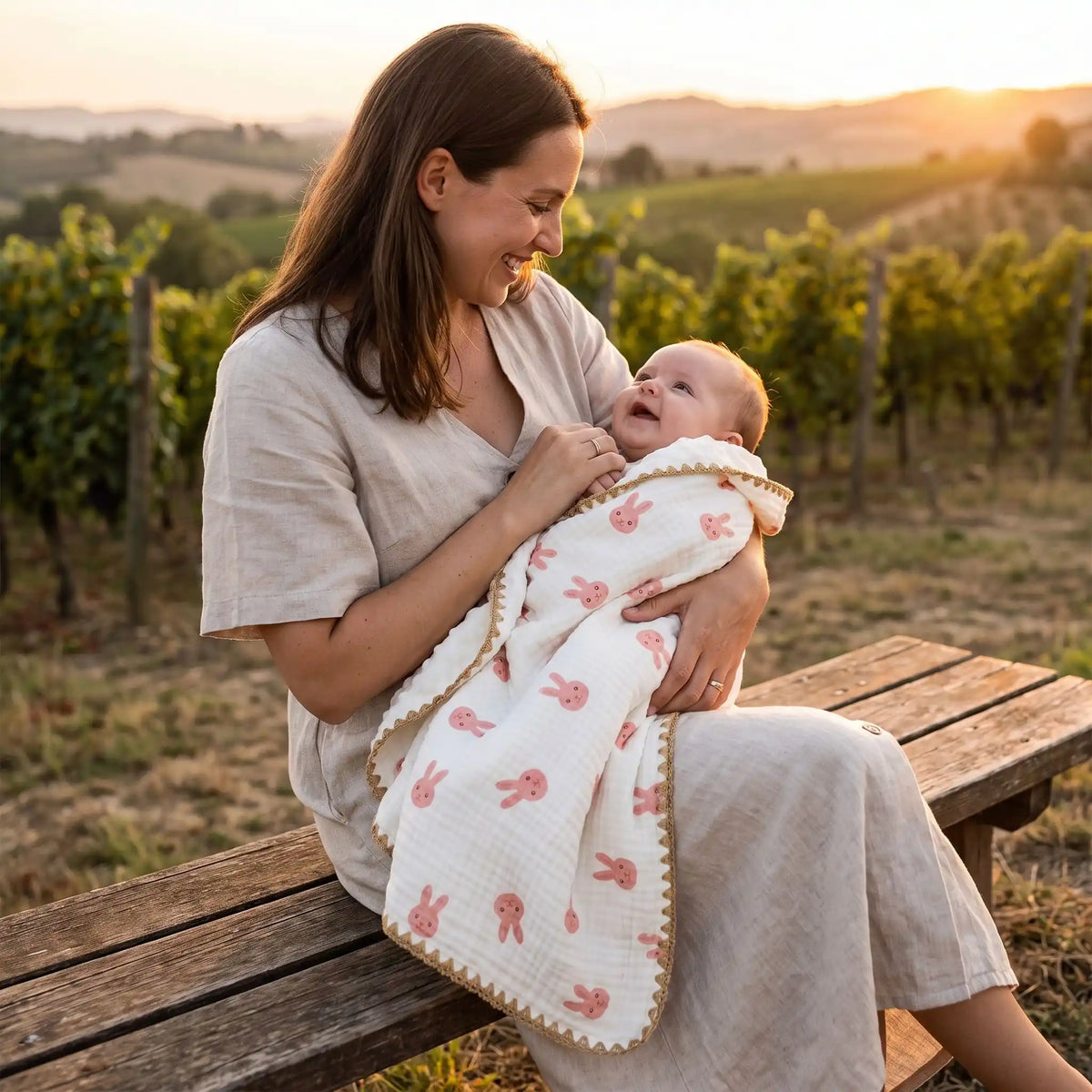 maman et bébé dans sa couverture bébé lapin dans un vignoble