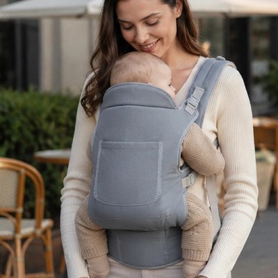 Porte bébé maman qui caline son bébé