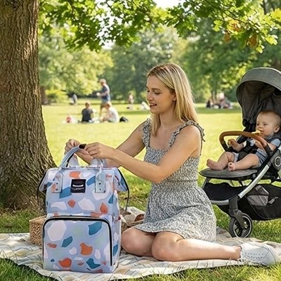 Sac a langer bebe au parc maman couverte et bebe dans la poussette