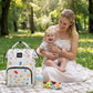 Sac a langer bebe et maman au parc sur une couverte
