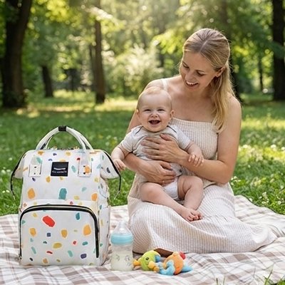 Sac a langer bebe et maman au parc sur une couverte